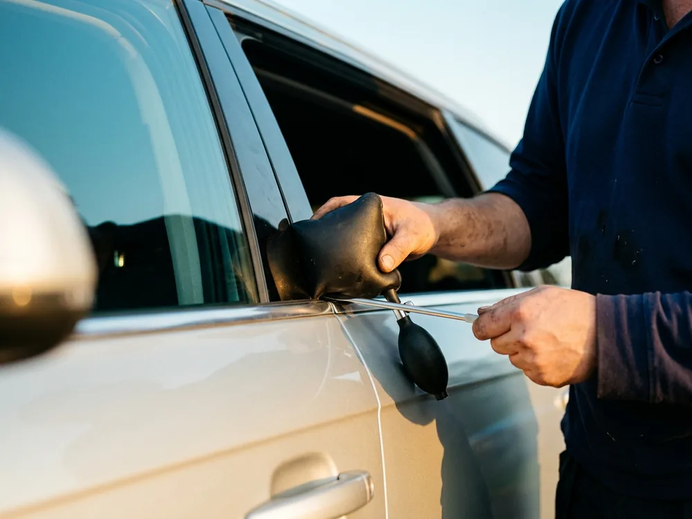 Air wedge and reach tool used for a damage-free opening at the top corner of a car door