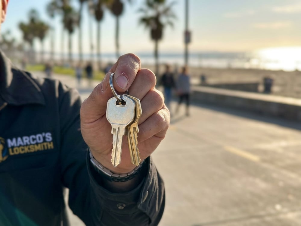 Freshly cut car keys held up beside the open service van